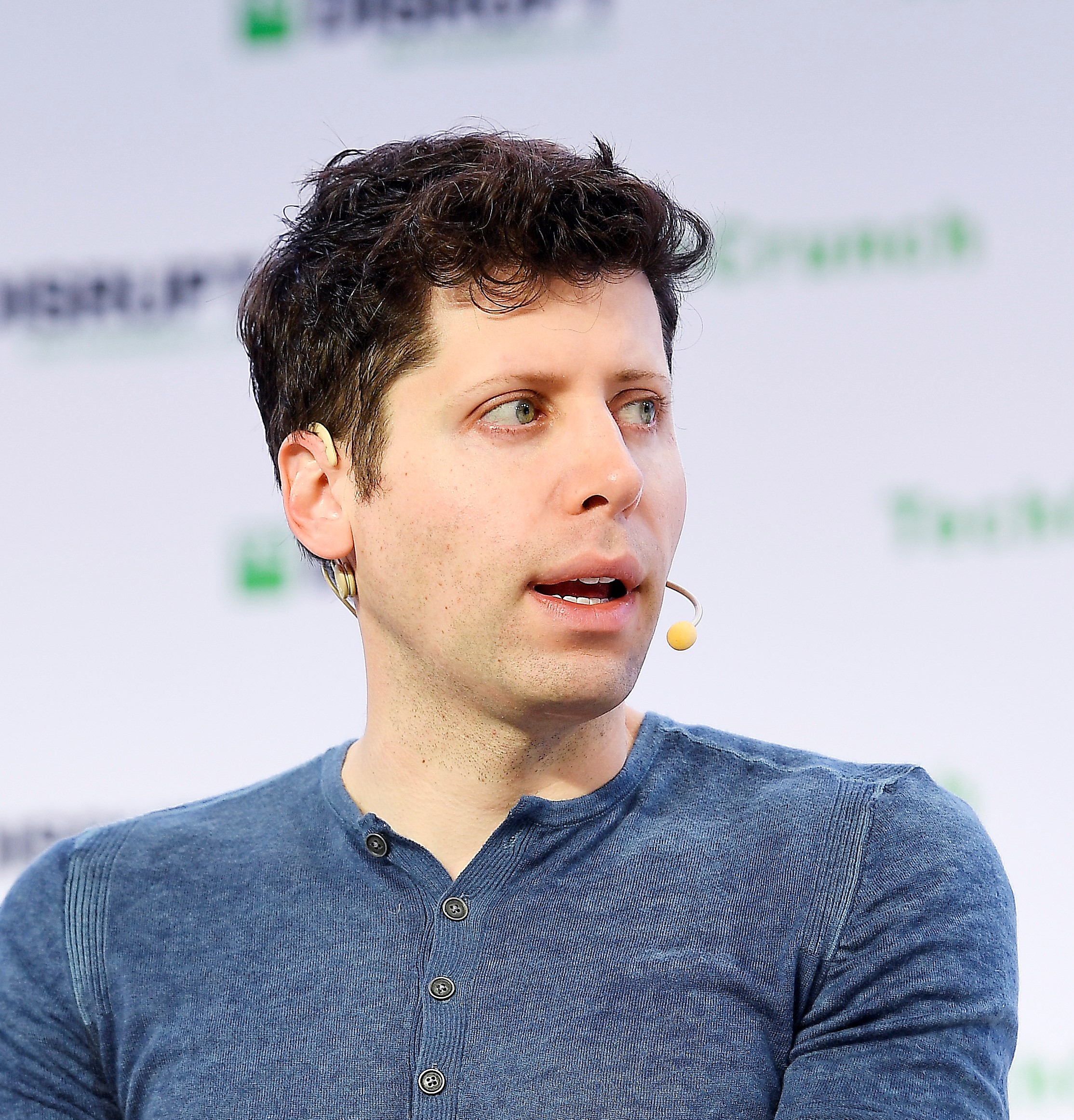 Sam Altman, chief executive of OpenAI, speaking on stage wearing a headset microphone